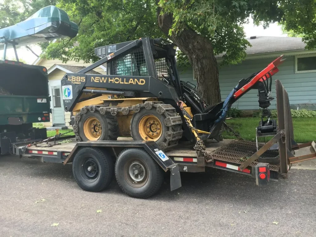 a small loader on a trailer, tree service minneapolis